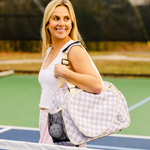 Woman carrying a fashionable women's pickleball bag with stylish brown checkered design.