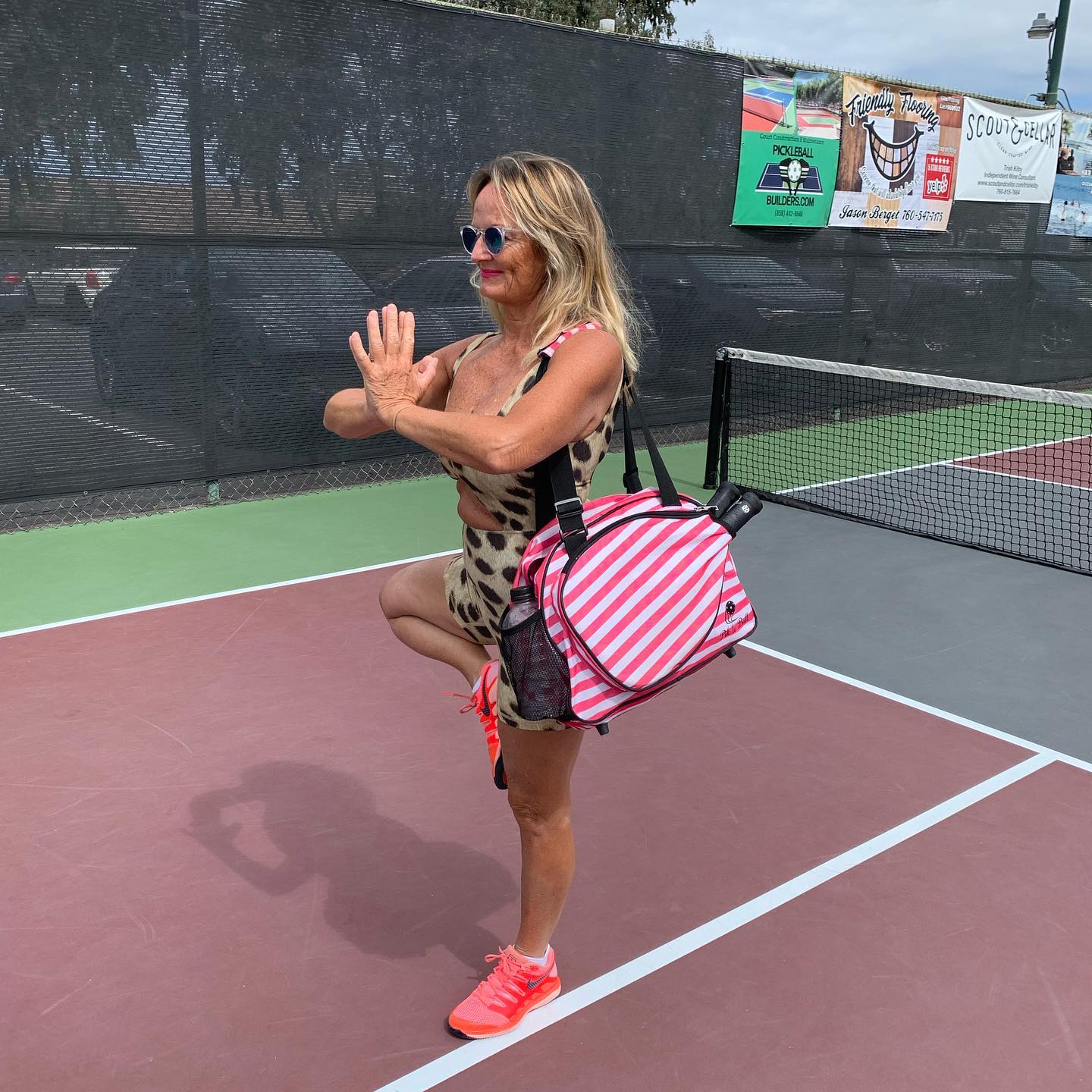 Stylish women on the pickleball court with pink stripe ladies sports bag and tote in a zen yoga pose
